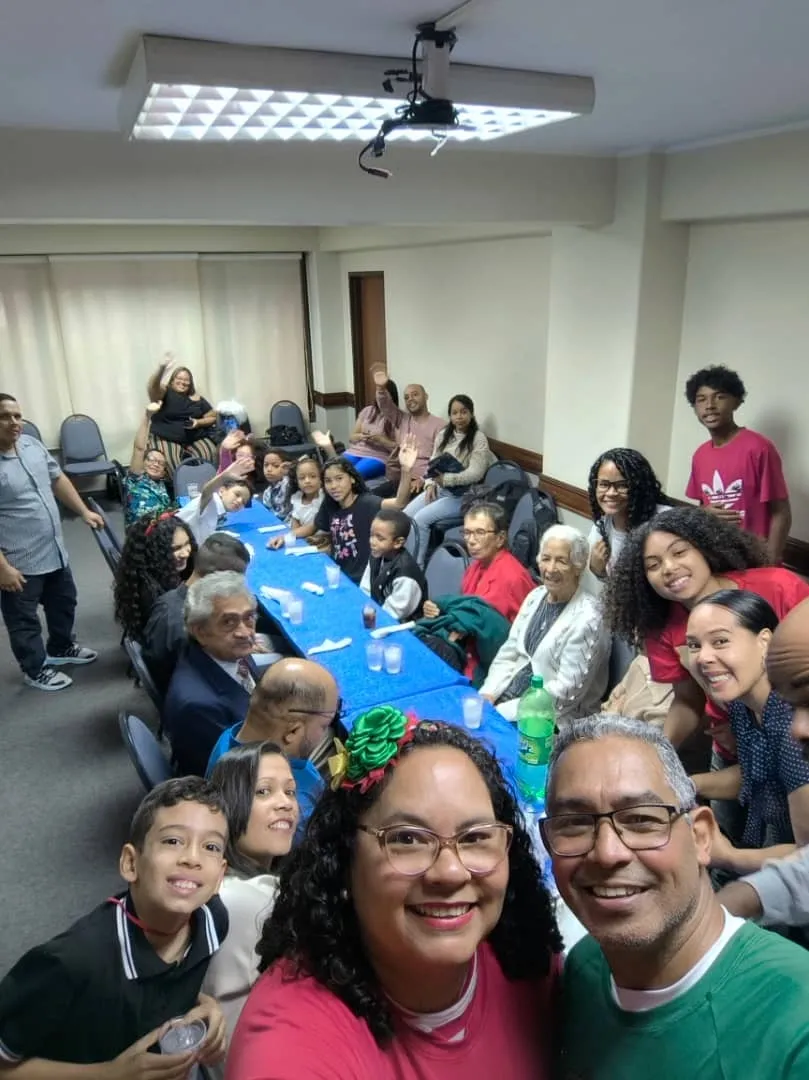 Familias, niños y adultos de la iglesia reunidos alrededor de las mesas